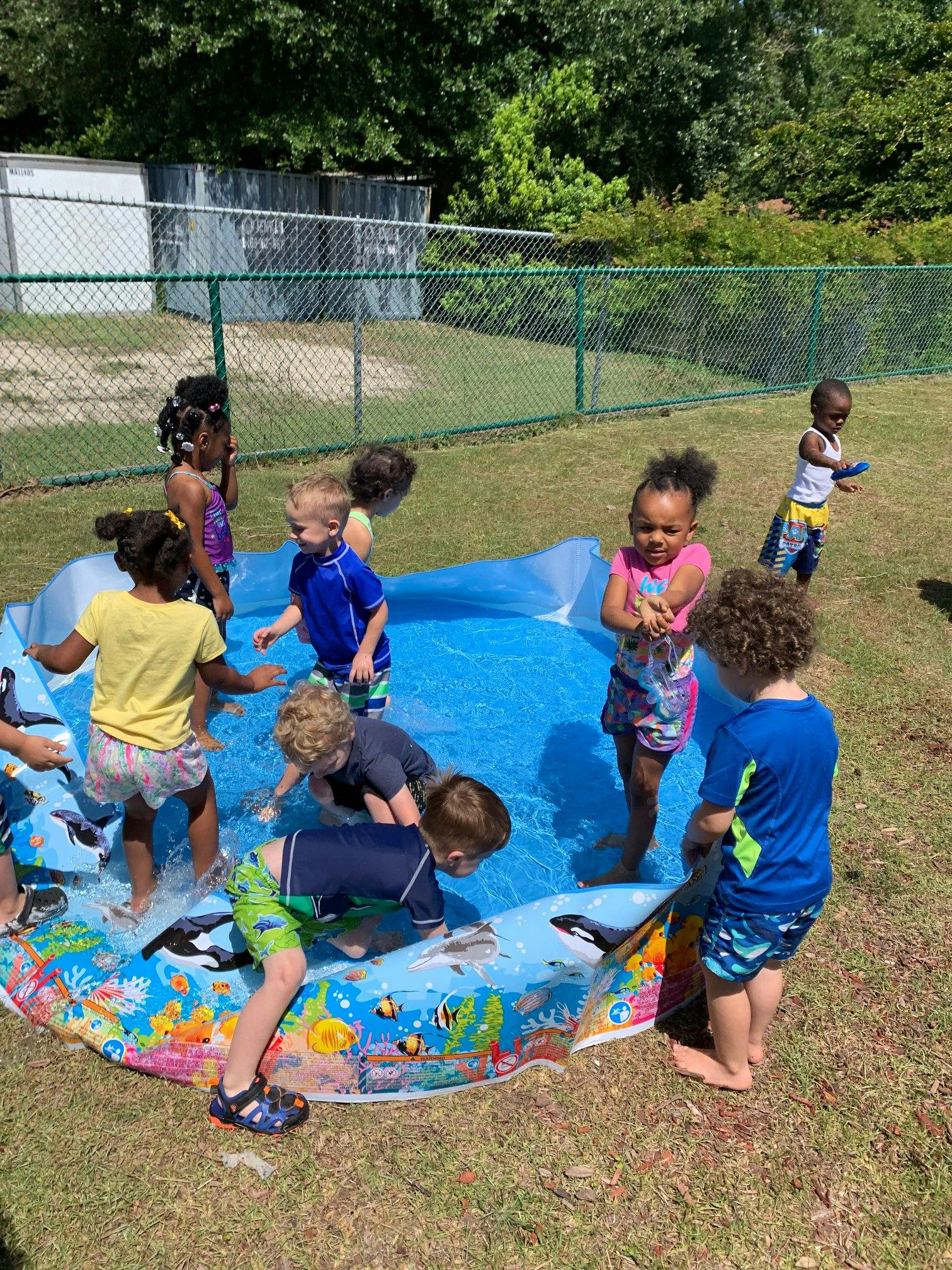 Children playing in a small inflatable pool outdoors