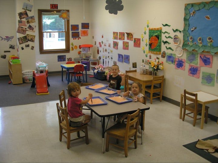 Children sitting at tables in a classroom