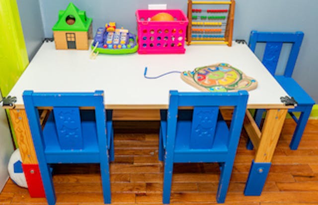 Children's table with blue chairs and toys