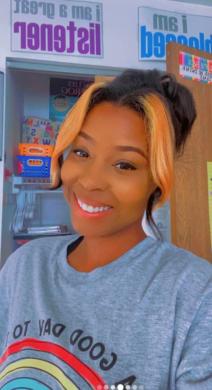 Person with dark hair and blonde highlights smiling