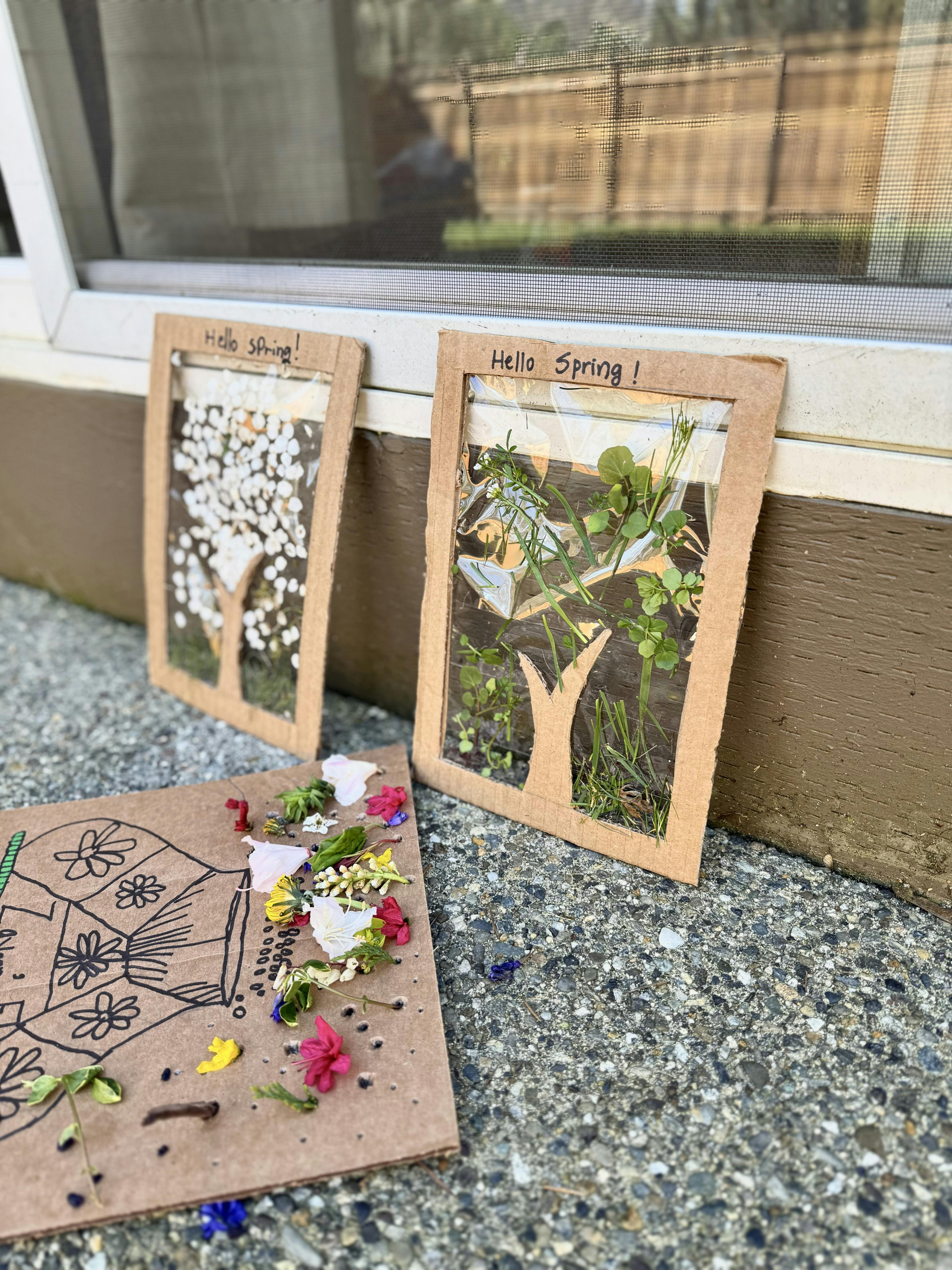 Crafts made from cardboard, flowers, and leaves with 'Hello Spring!' written on two of them