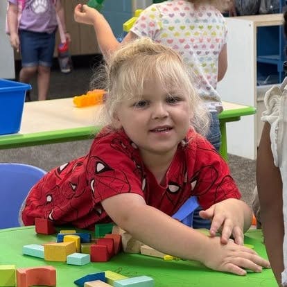 Child playing with colorful blocks at a table