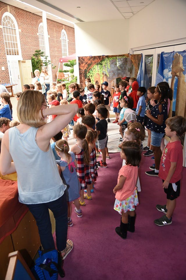 Adult and children standing in a line indoors