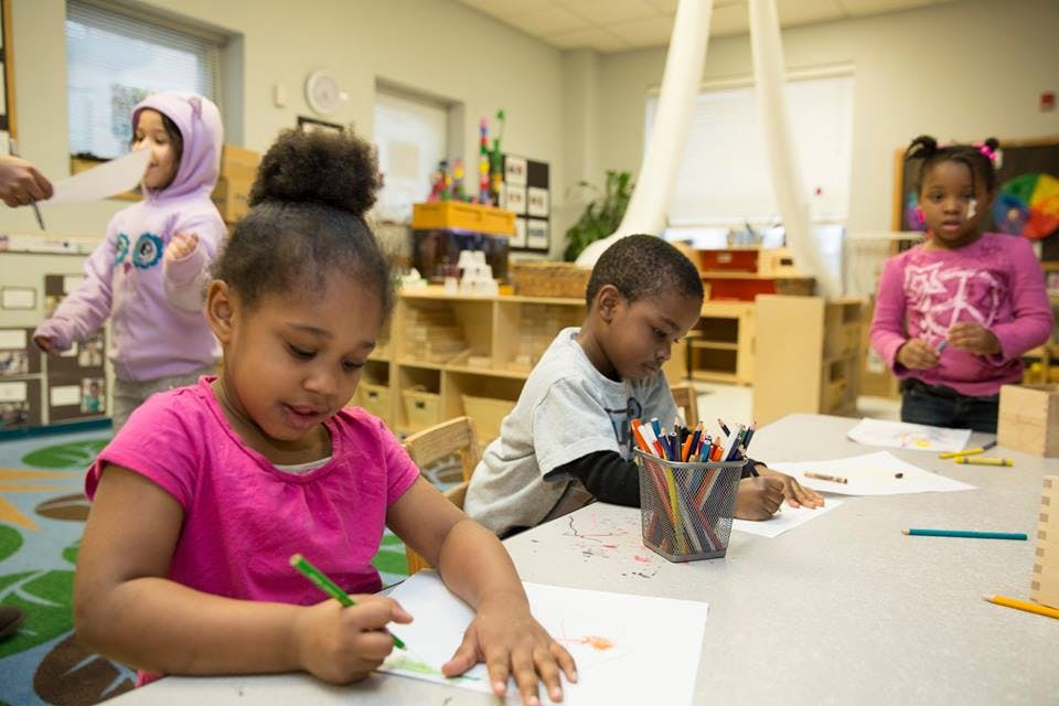 Children drawing at a table in a classroom