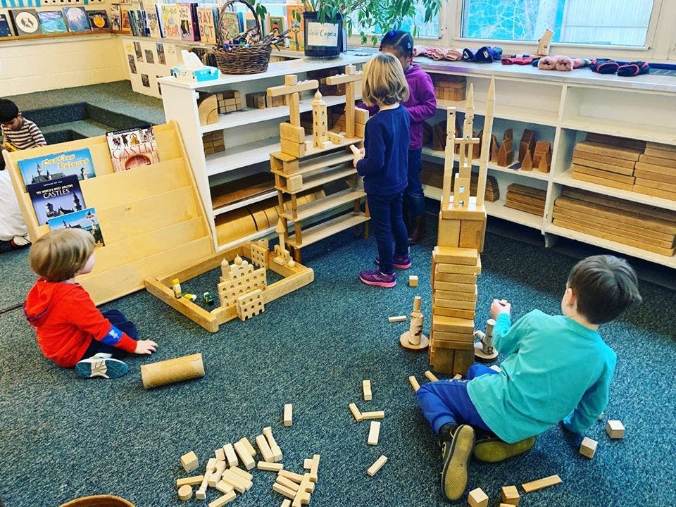 Children playing with wooden blocks in a classroom