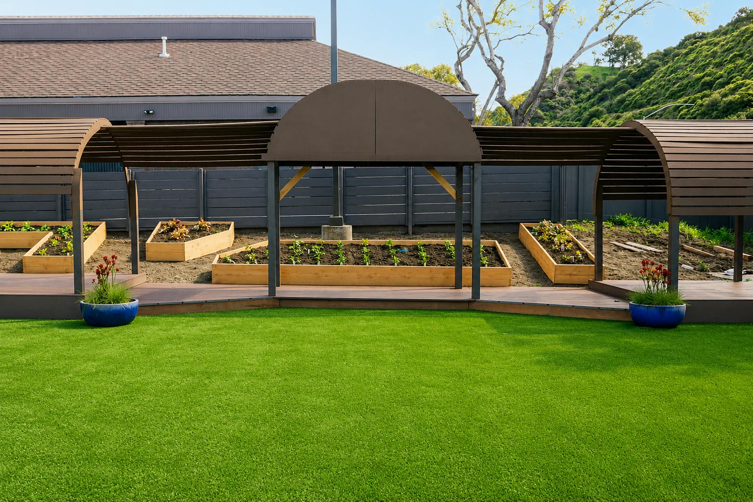 Raised garden beds under arched wooden shade structures in a backyard