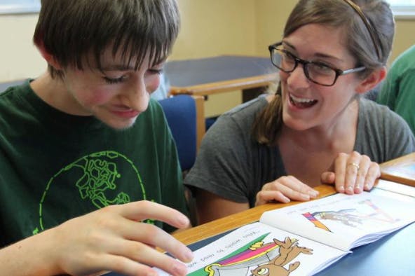Adult and child reading a book together