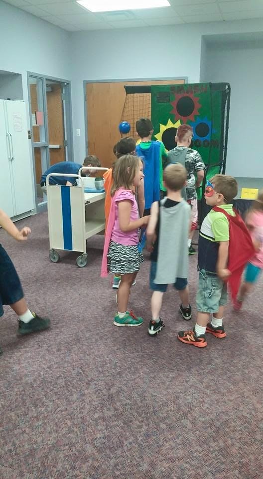 Children in capes standing in a room