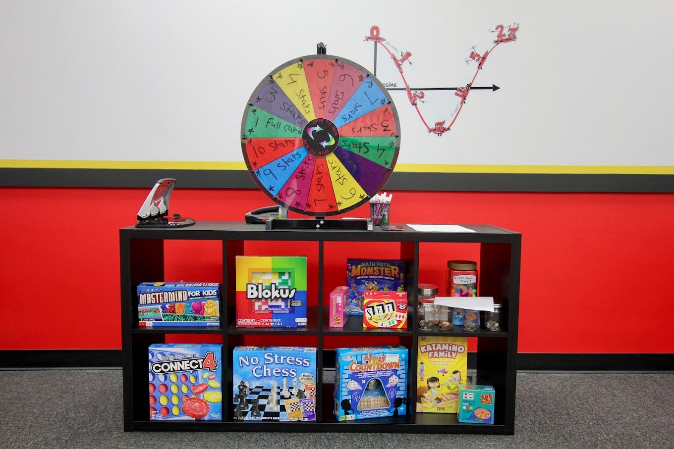 game shelf with a prize wheel on top and a math graph on the wall