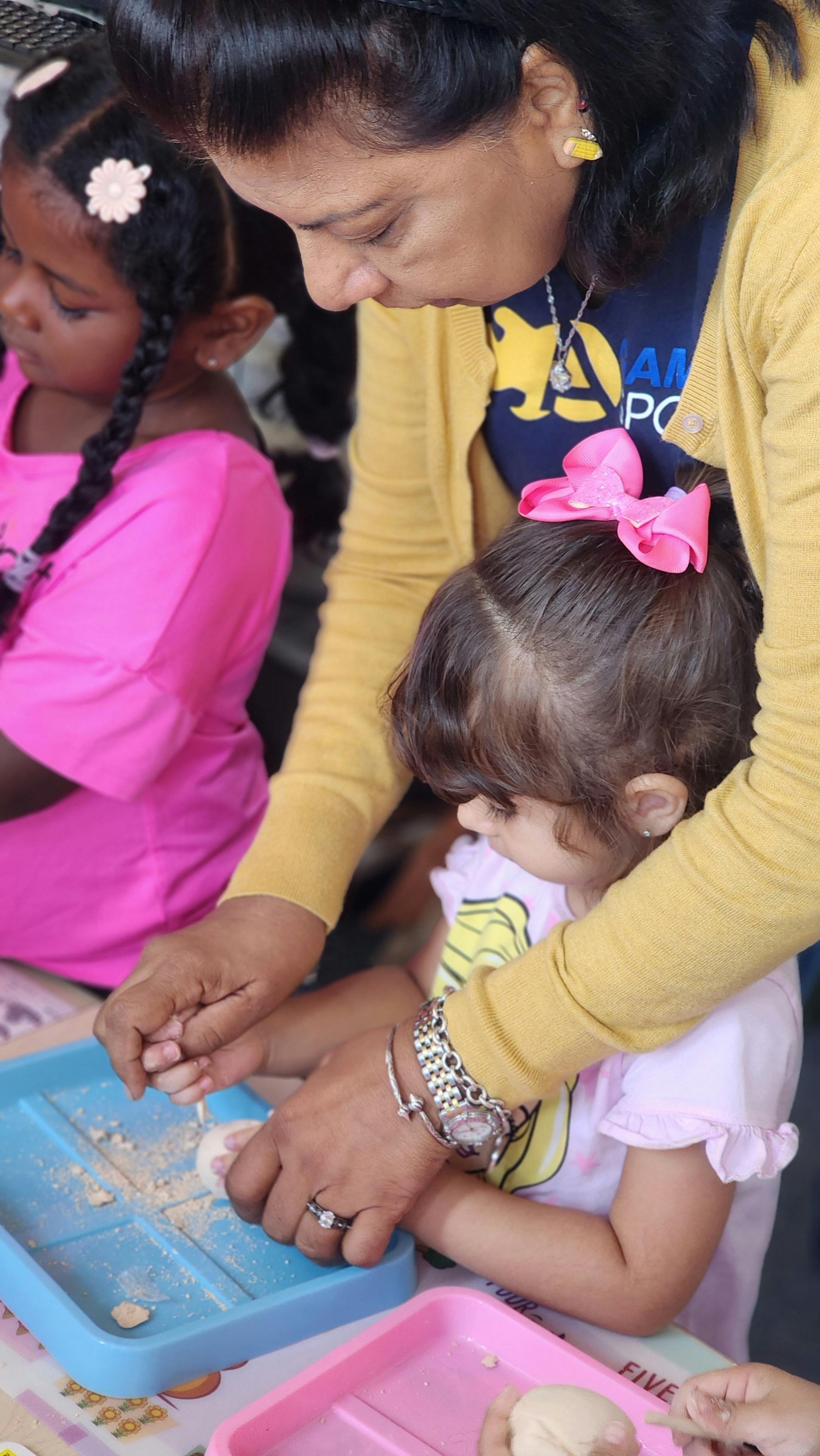 Person helping a child with an activity tray