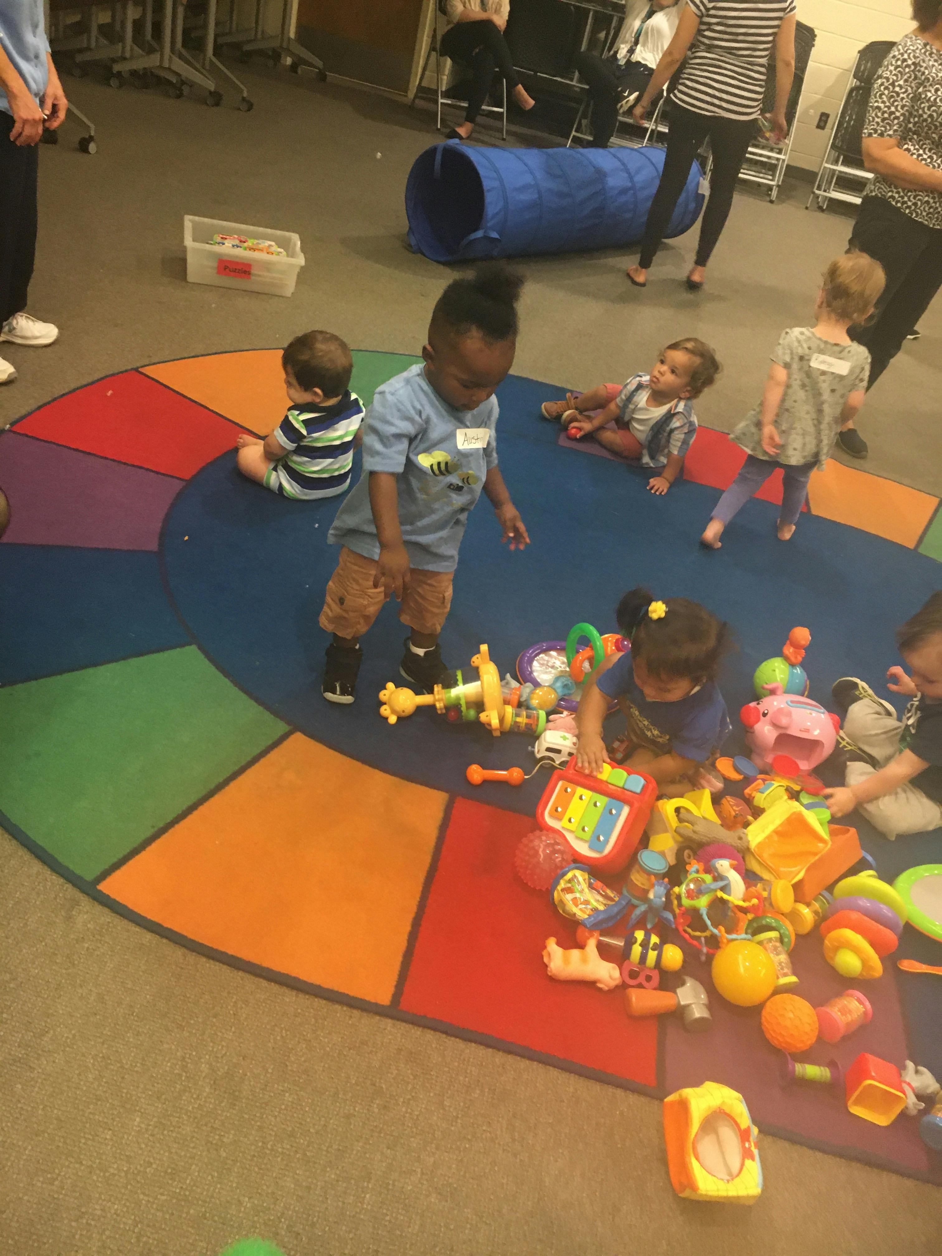 Children playing with toys on a colorful rug