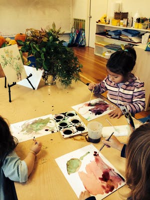 Children painting with watercolors at a table