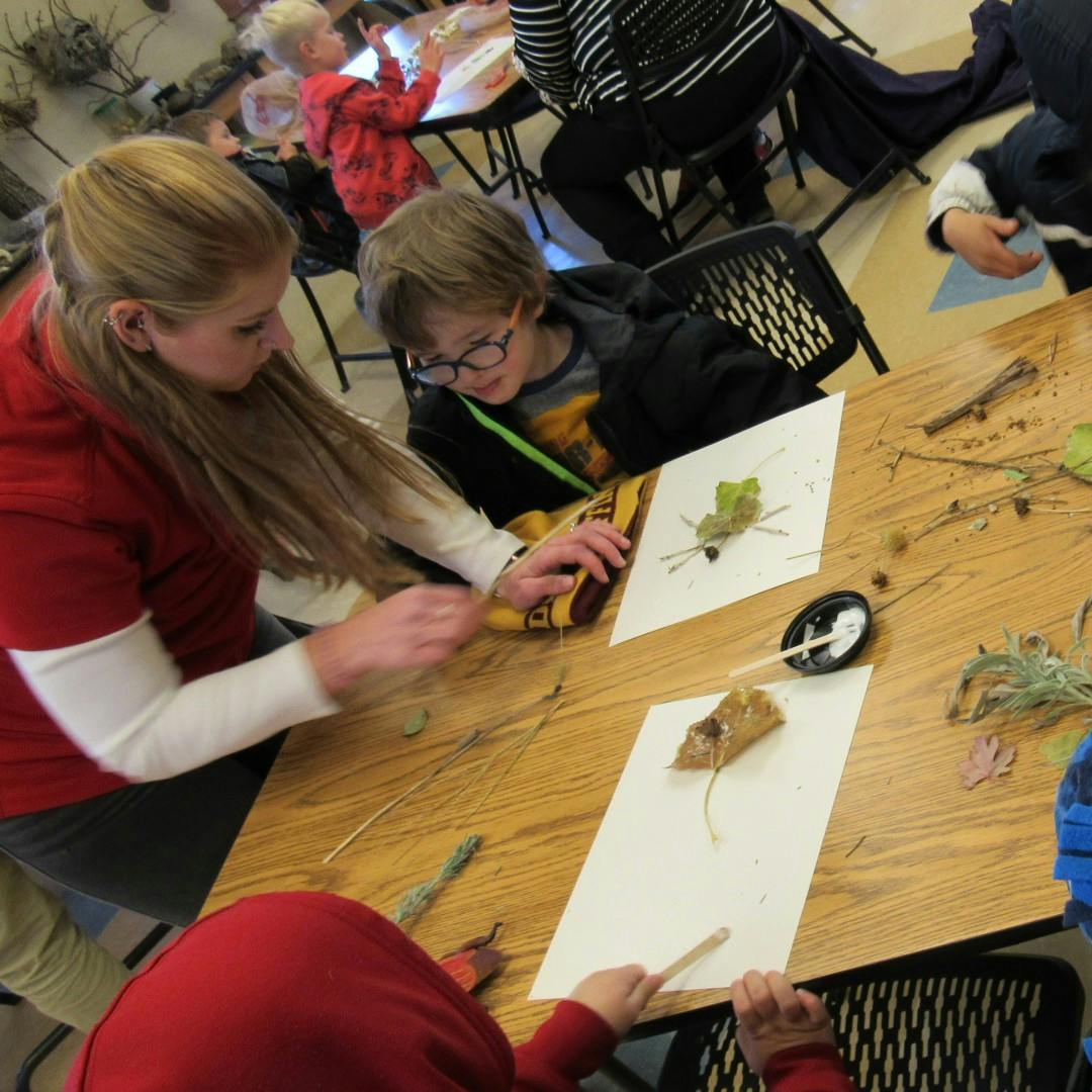 Adult and child working on a craft project with natural materials