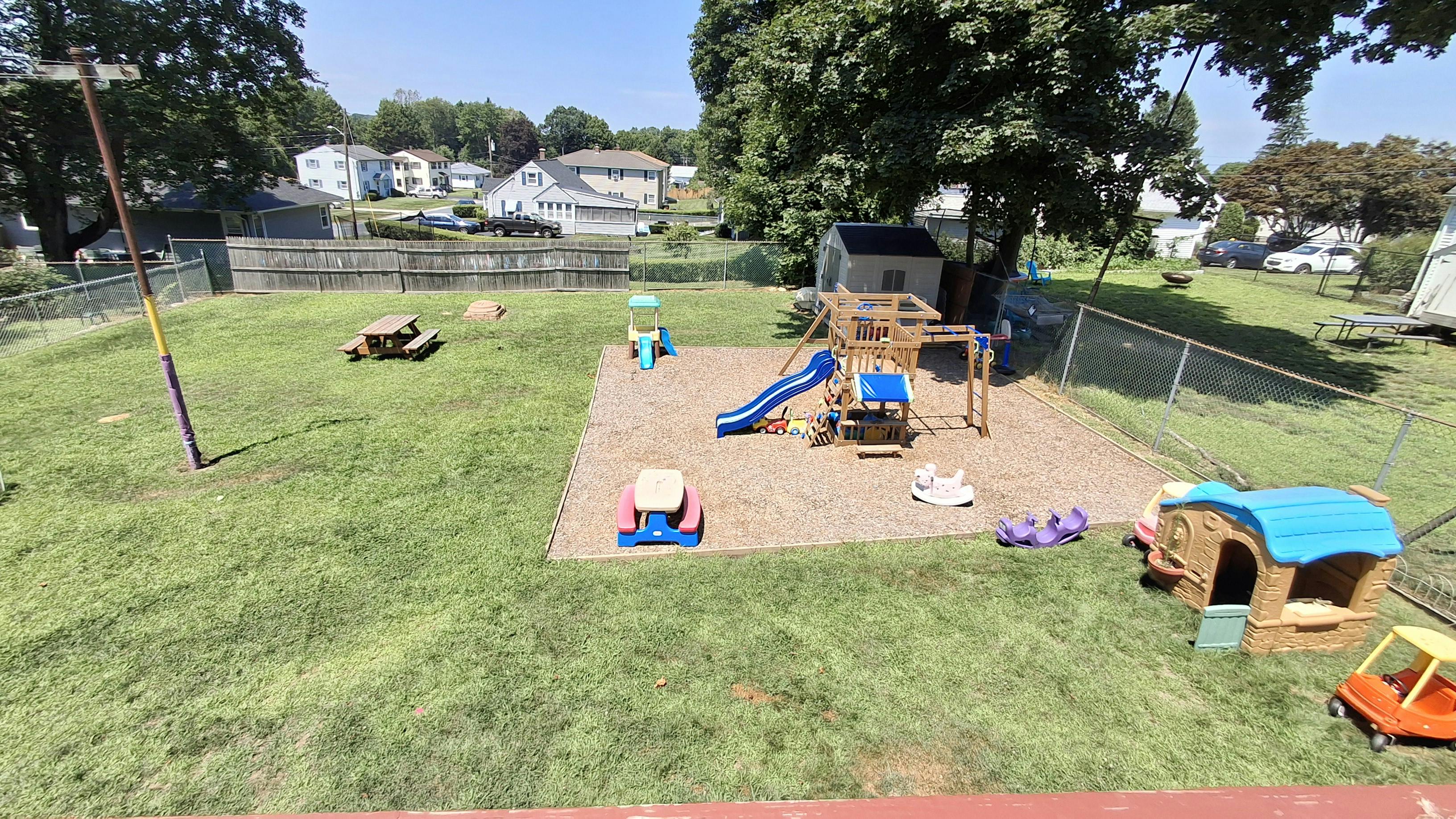 Outdoor playground with slides, swings, and playhouses on sand and around sand
