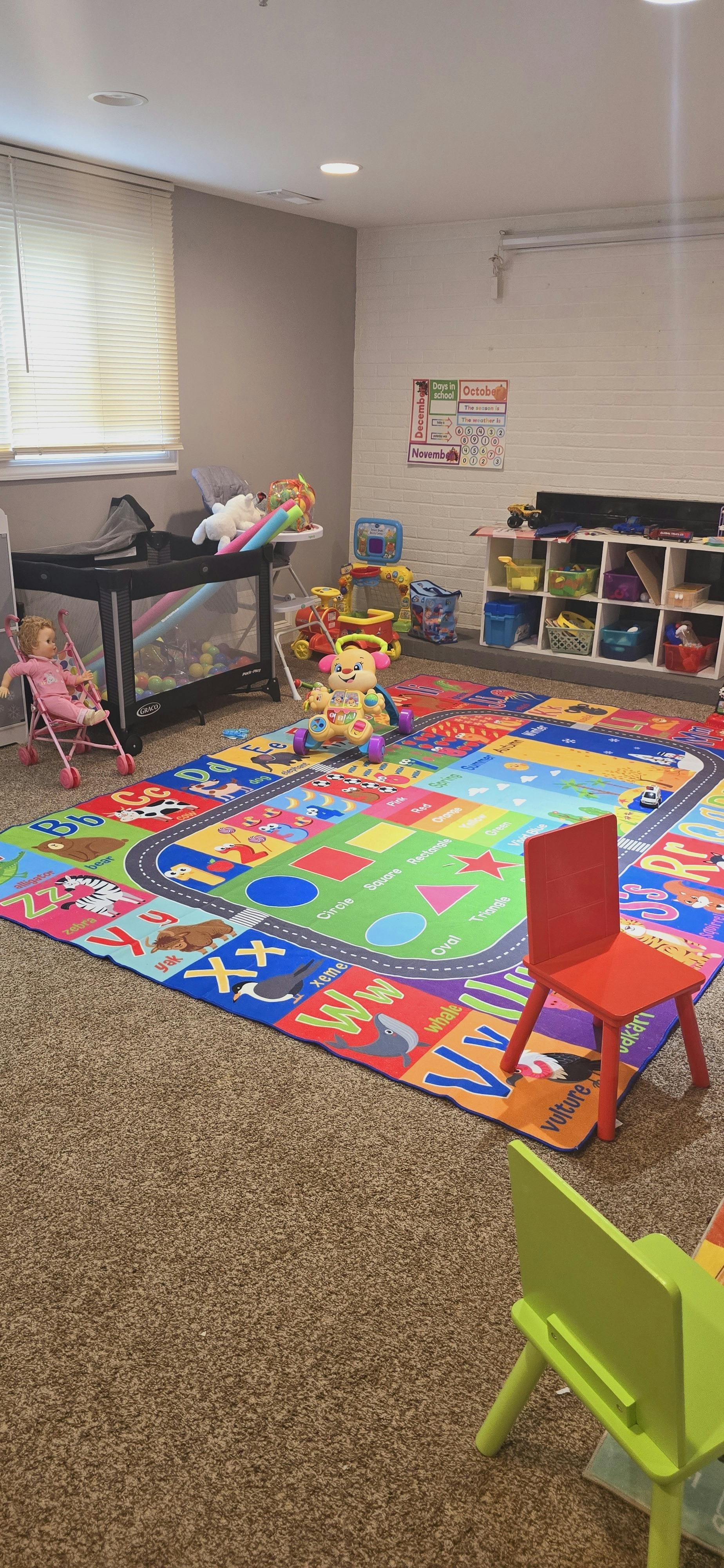Playroom with a colorful ABC mat, baby doll in a stroller, and toys