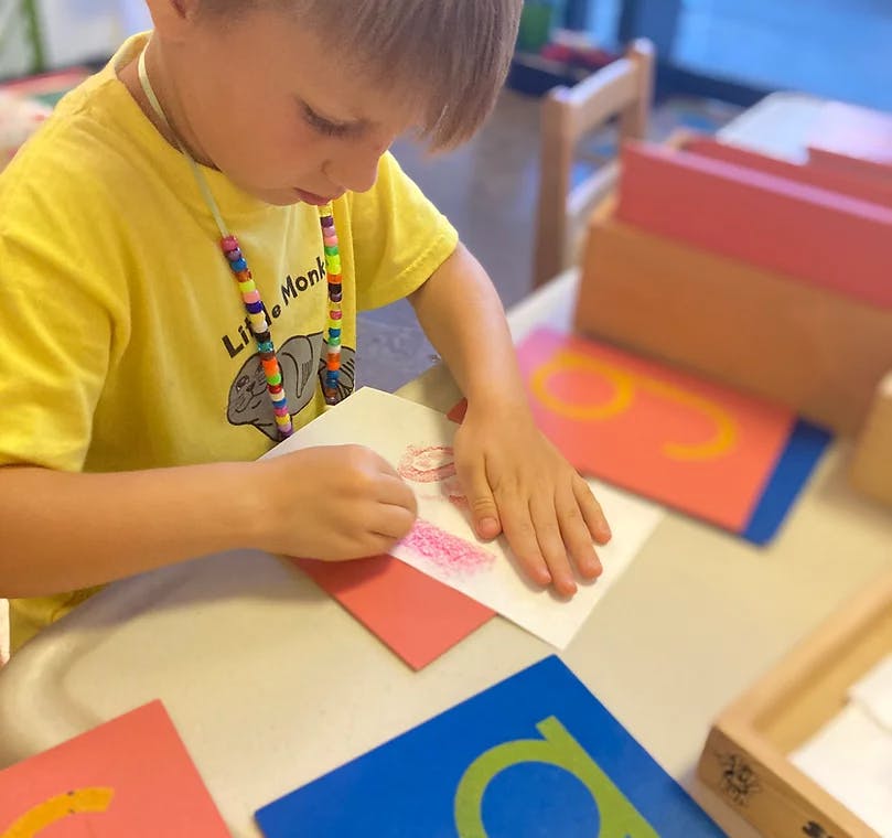 Child drawing on paper at a table