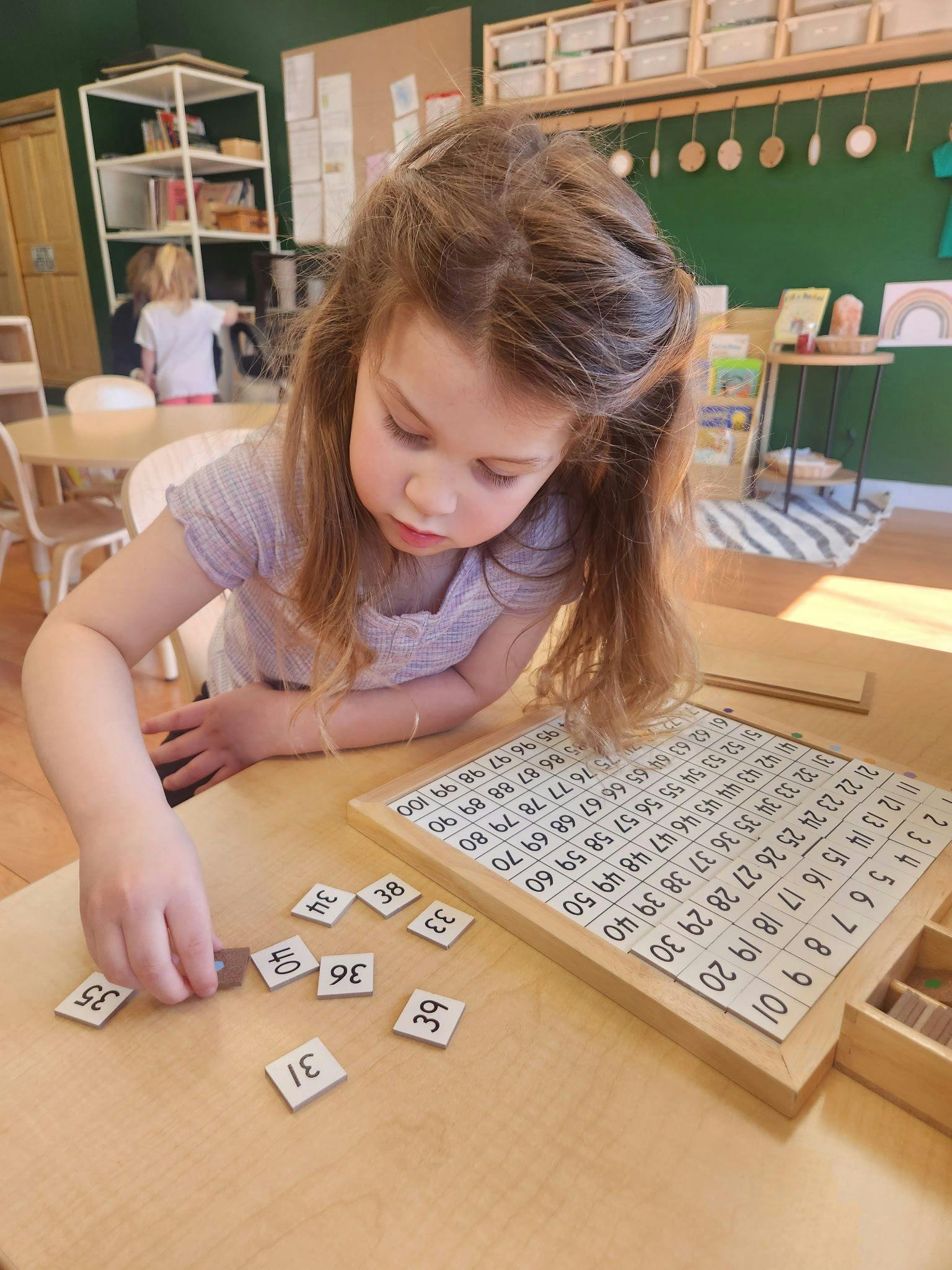 Child learning numbers with counting blocks and number board