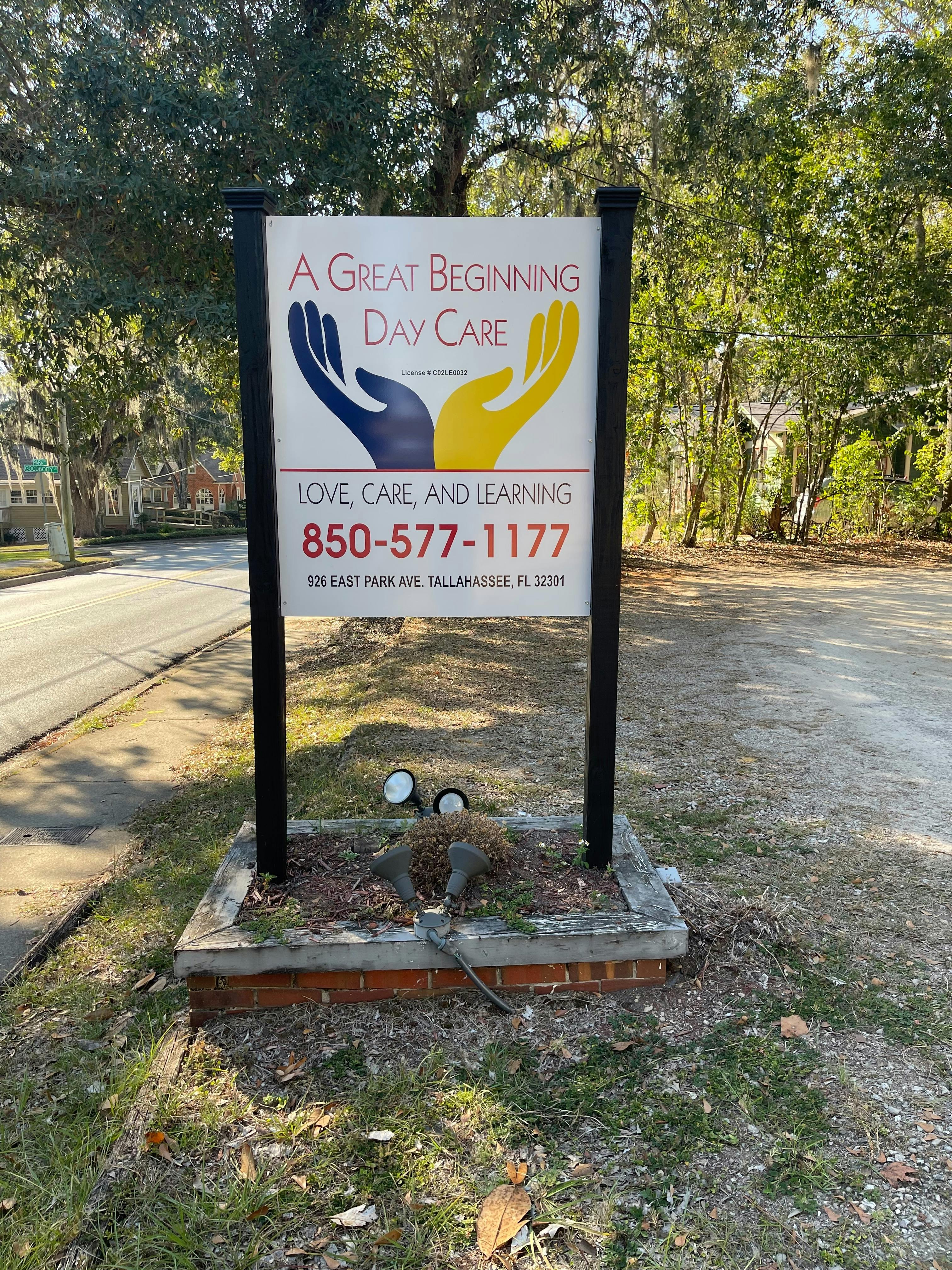 A Great Beginning Day Care sign with two hands and contact information