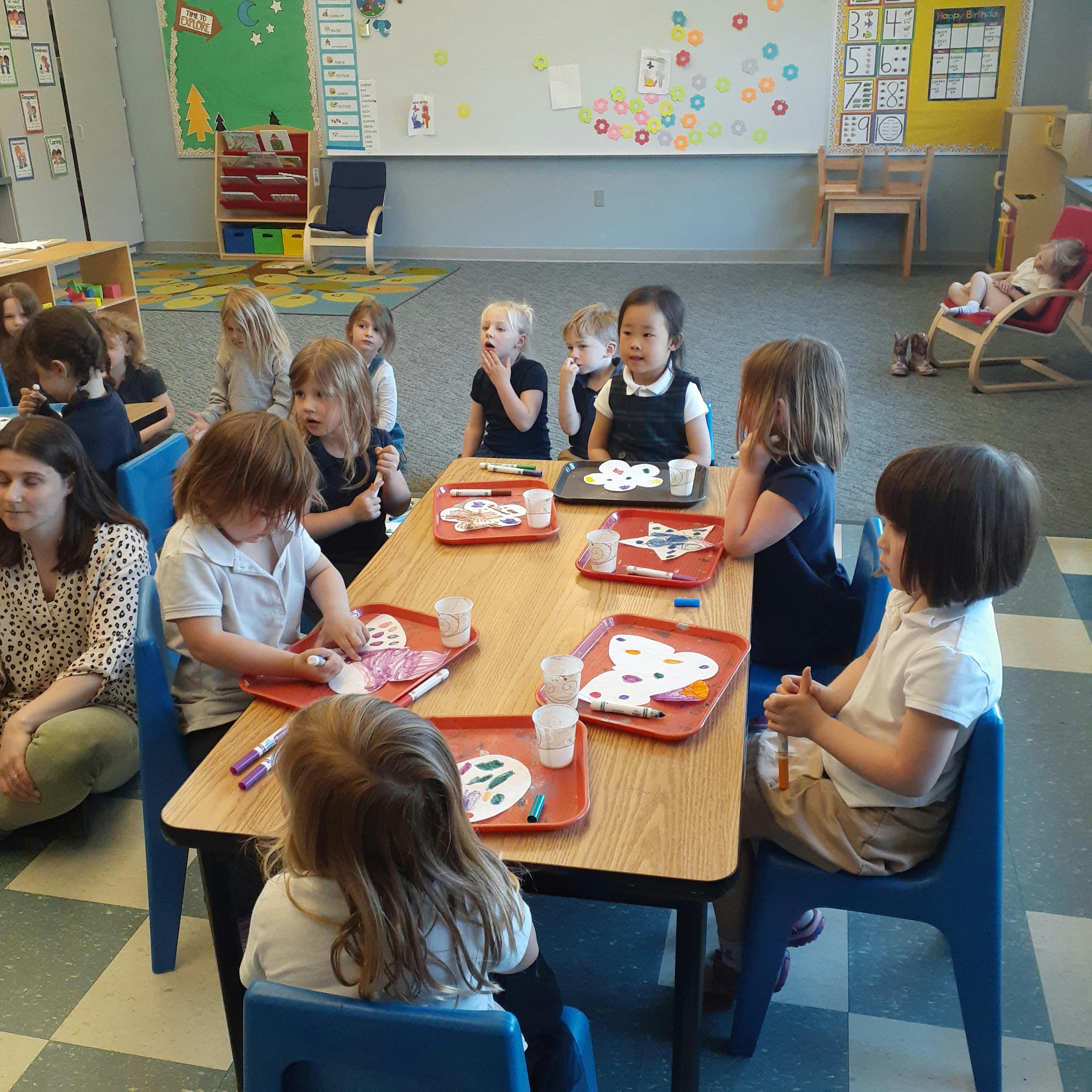 Children at a table doing an art activity in a classroom