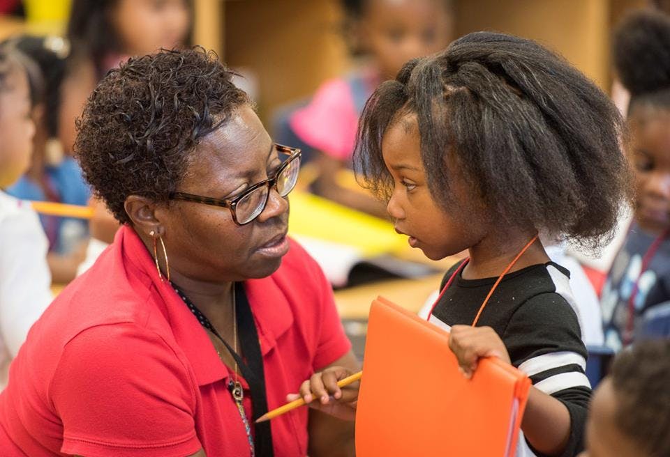 Adult and child looking at each other in a classroom