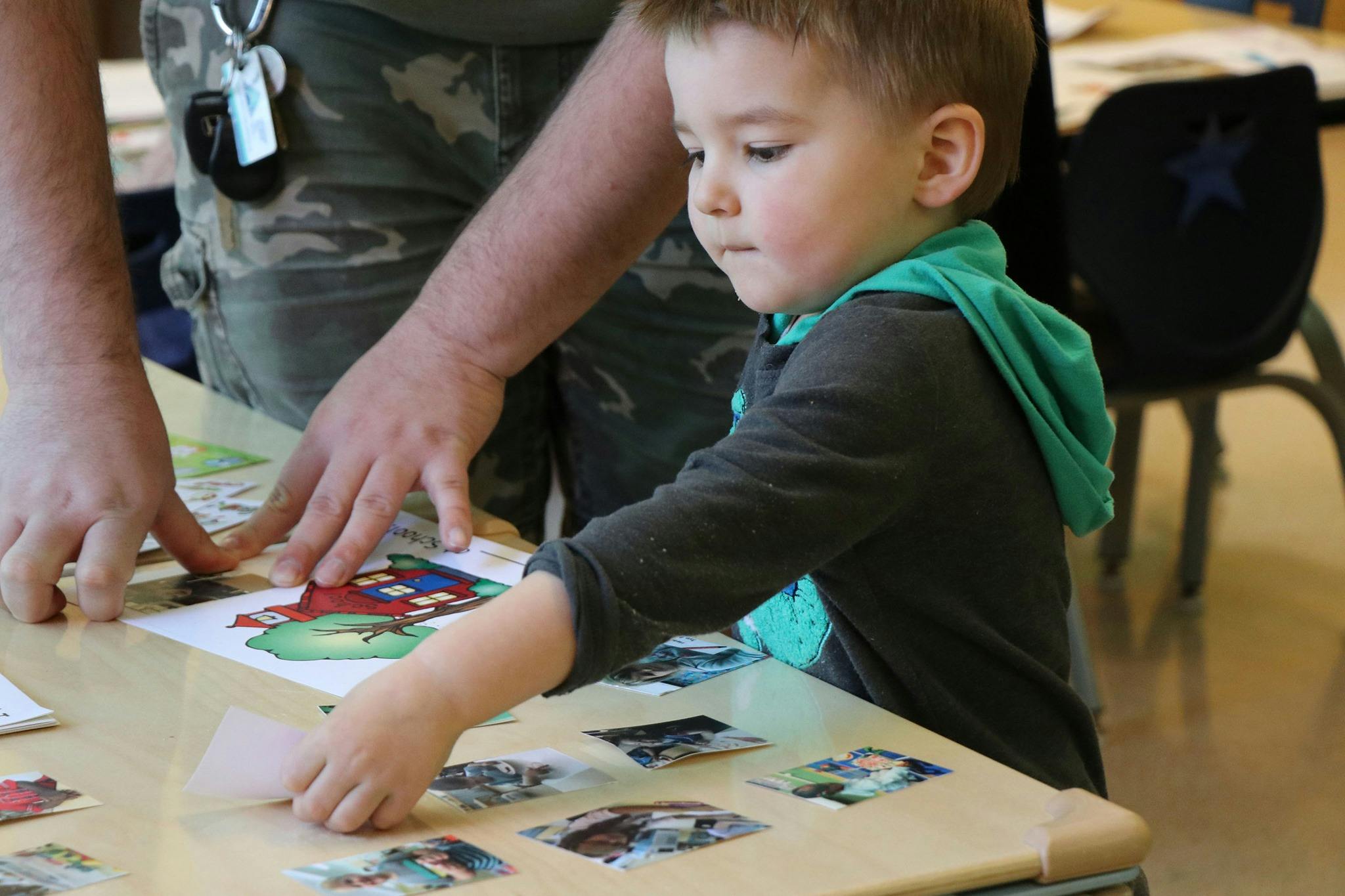 Adult and child playing with cards on a table