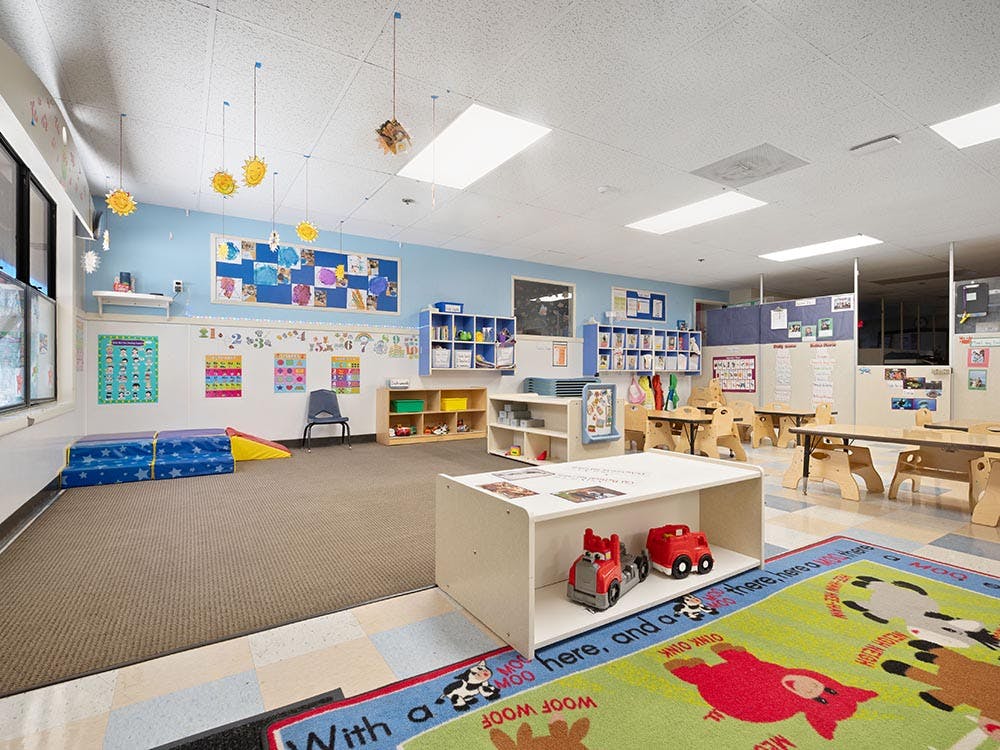 Children's classroom with small tables, chairs, and colorful decorations