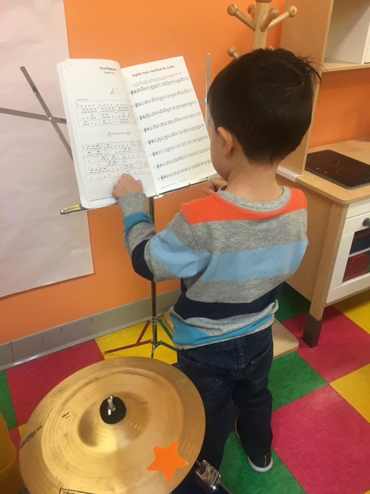 Child standing at a music stand with sheet music