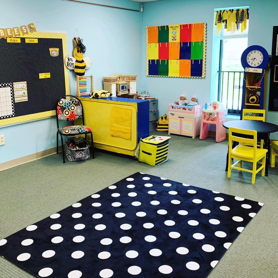 Classroom with a black and white polka dot rug, small tables, and chairs