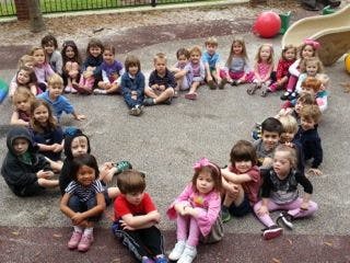 Group of children sitting in a circle on a playground