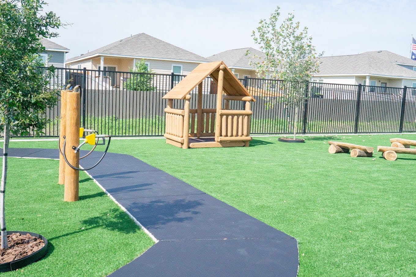 Wooden playhouse on a grassy playground with a path