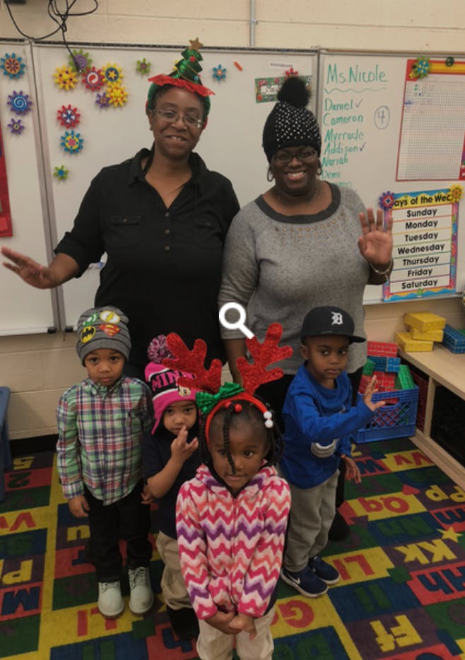Two people and four children in a classroom