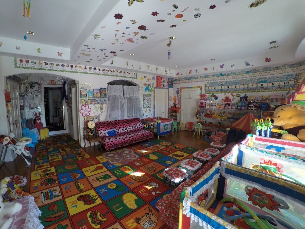 Playroom with colorful alphabet rug, sofa, and toys