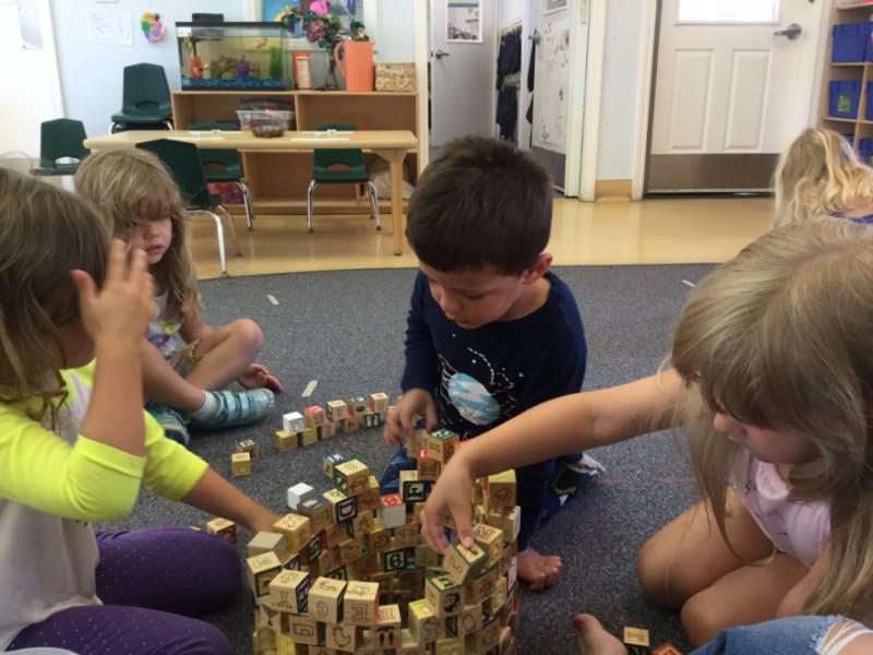 Children playing with wooden blocks on the floor