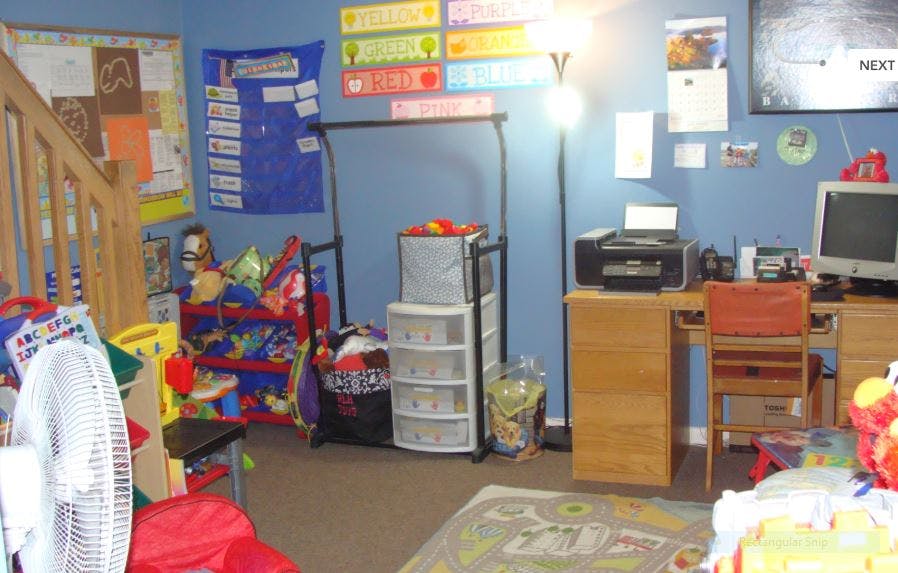 Room with a desk, computer, printer, and storage units
