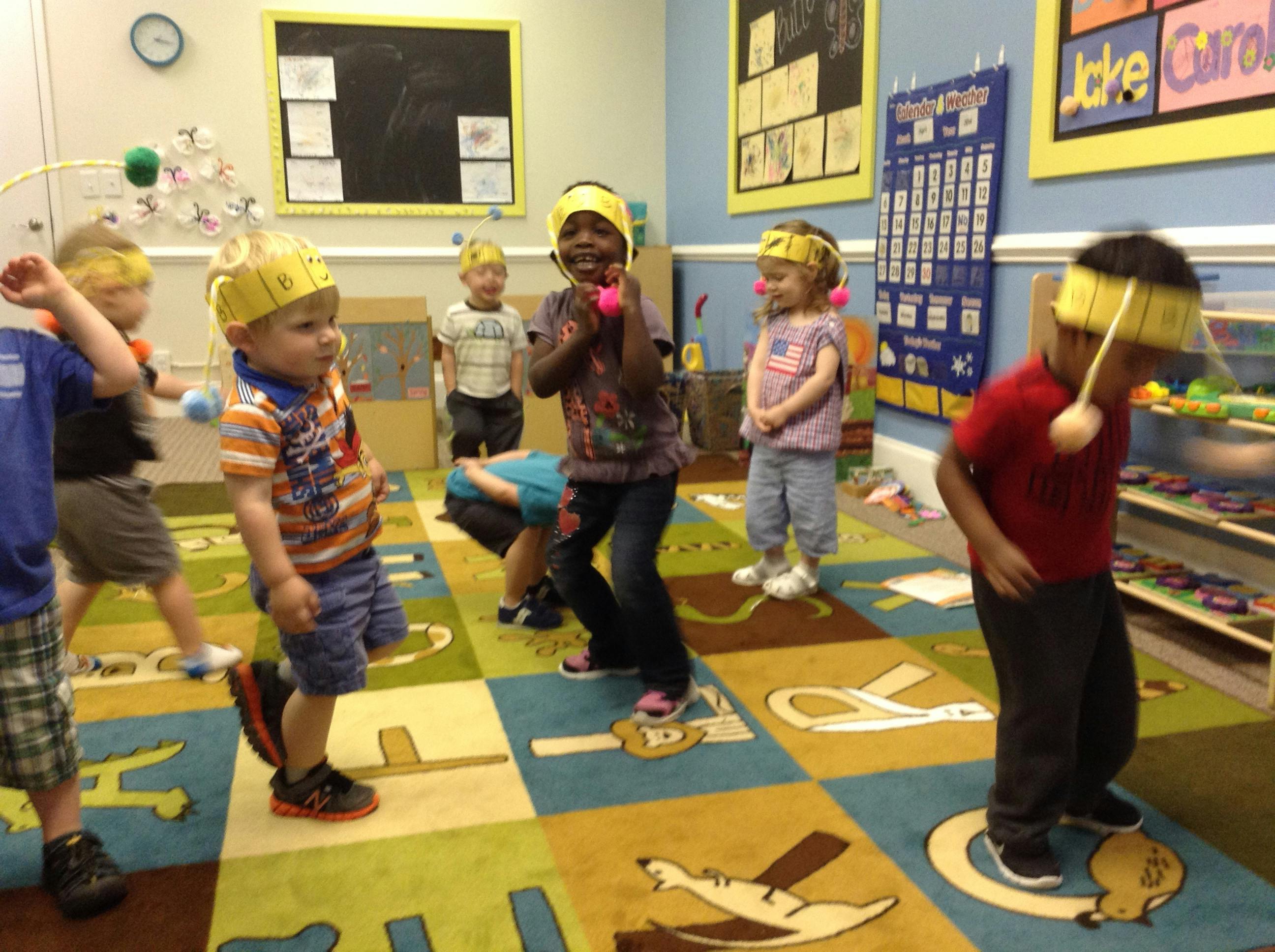 Group of children wearing paper headbands in a classroom
