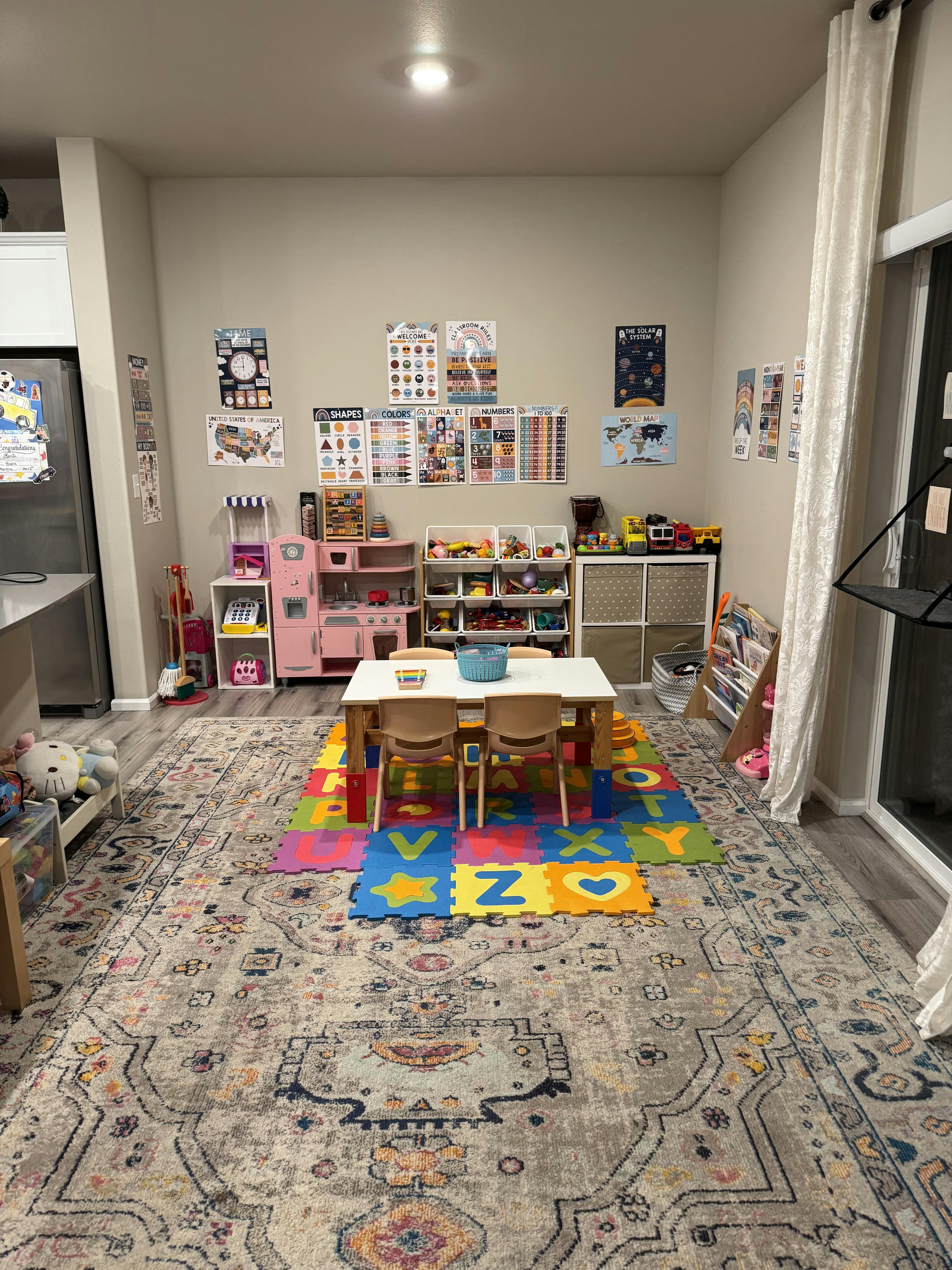 Playroom with a small table and chairs on an alphabet mat