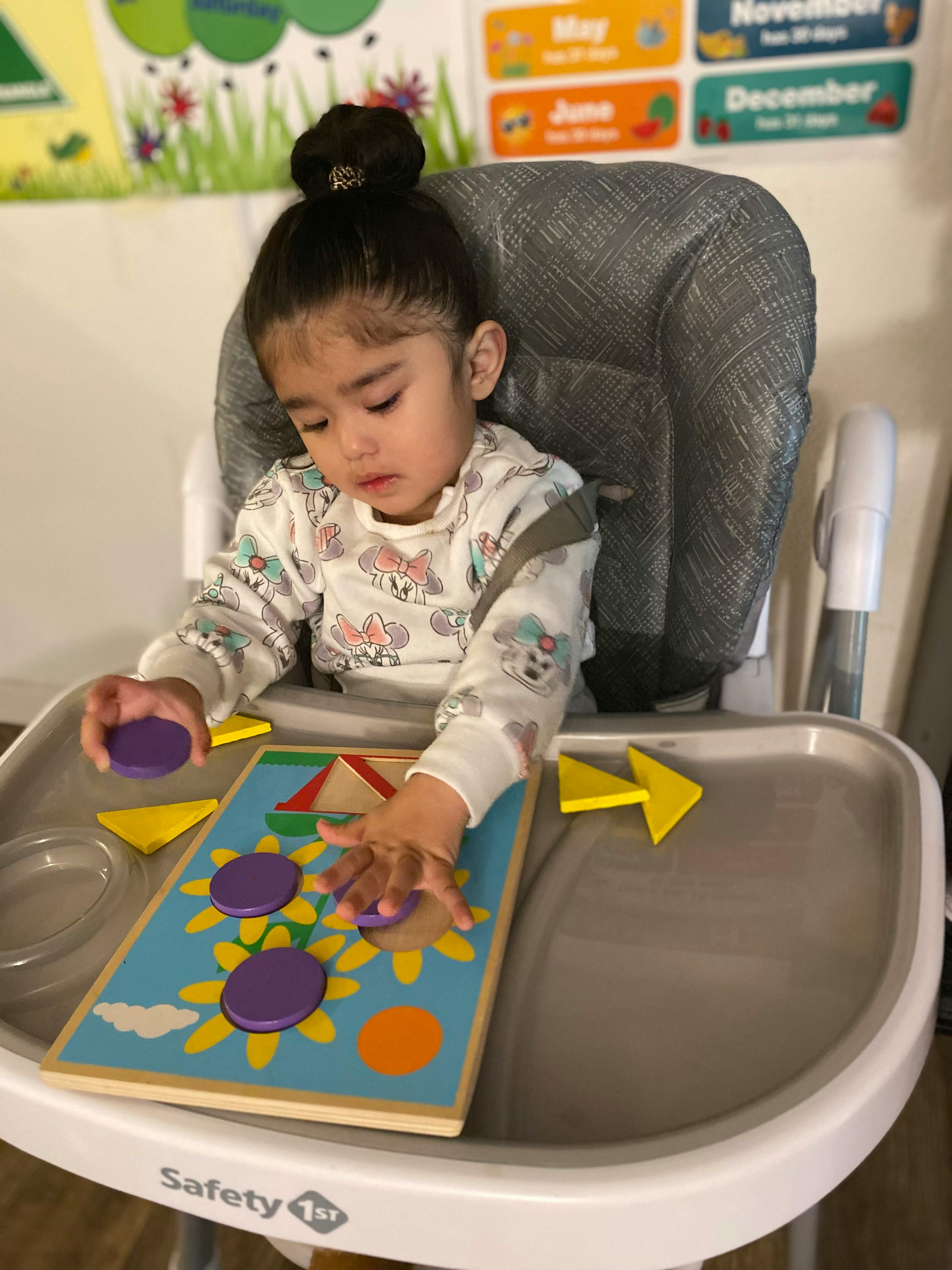 Child in a high chair playing with a puzzle