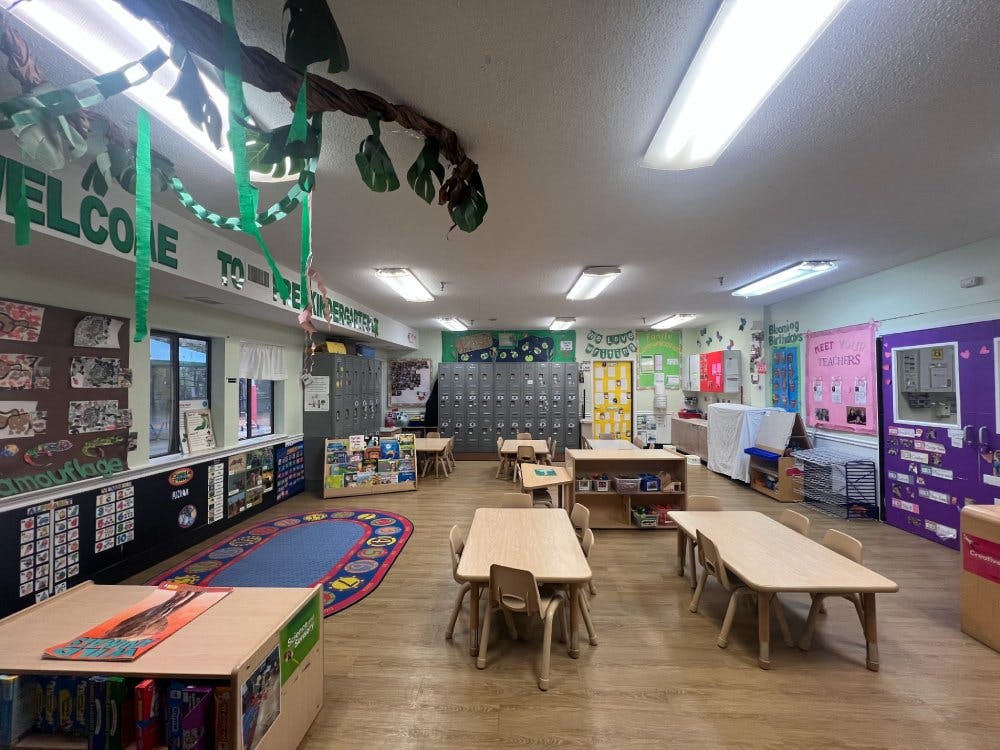 Empty kindergarten classroom with small tables and chairs