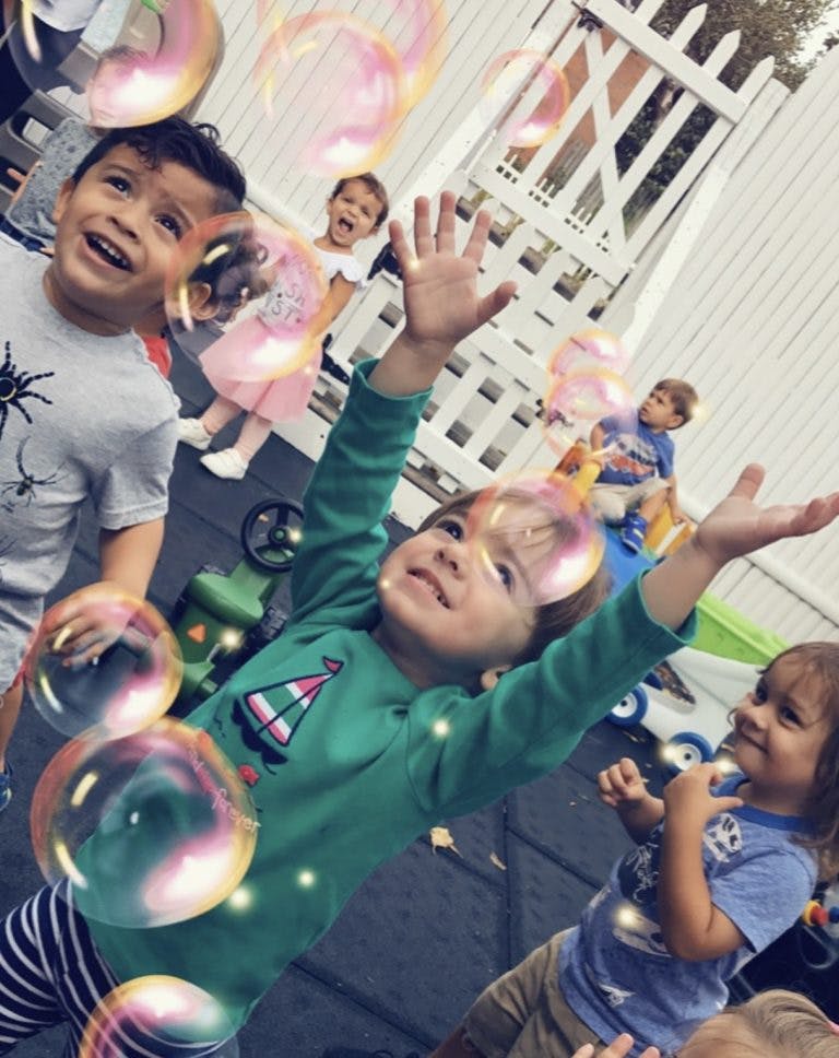 Children playing with bubbles outdoors