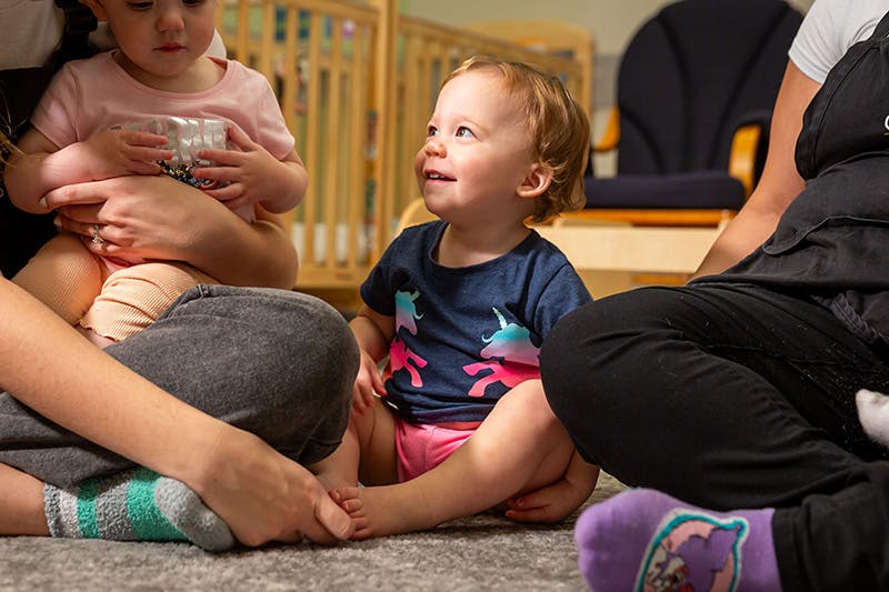 Two children sitting on the floor with adults