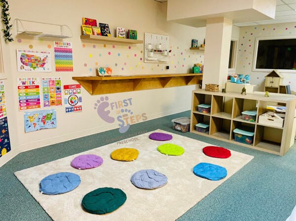 Colorful classroom with educational posters, shelves with toys, and floor cushions