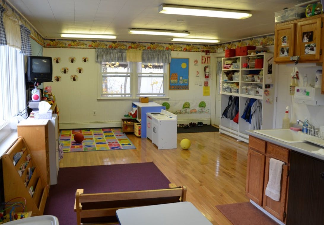 A classroom with wooden floors, windows, and various learning materials