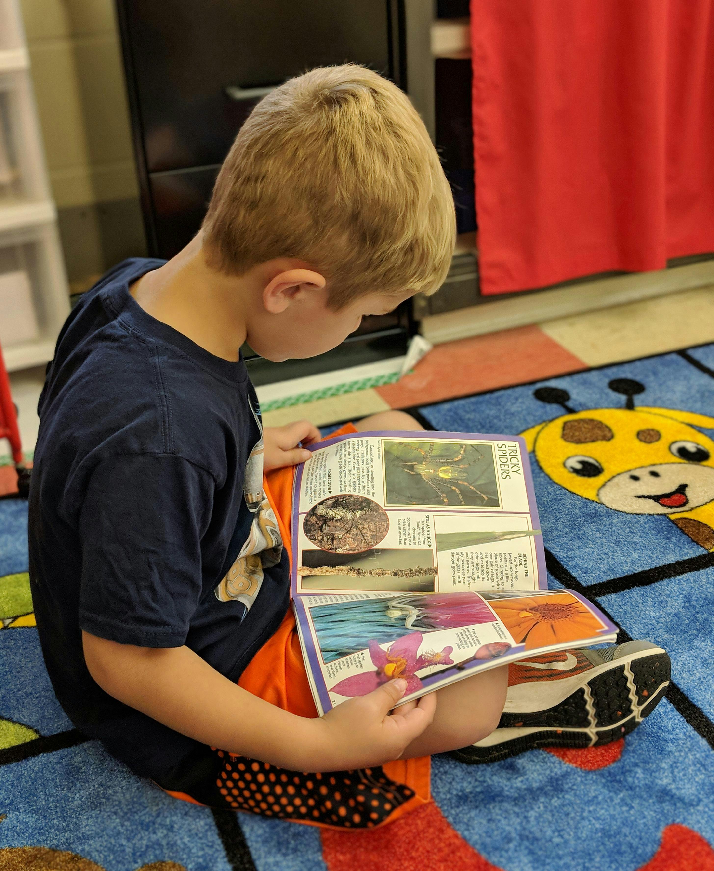 Child sitting on floor reading a book