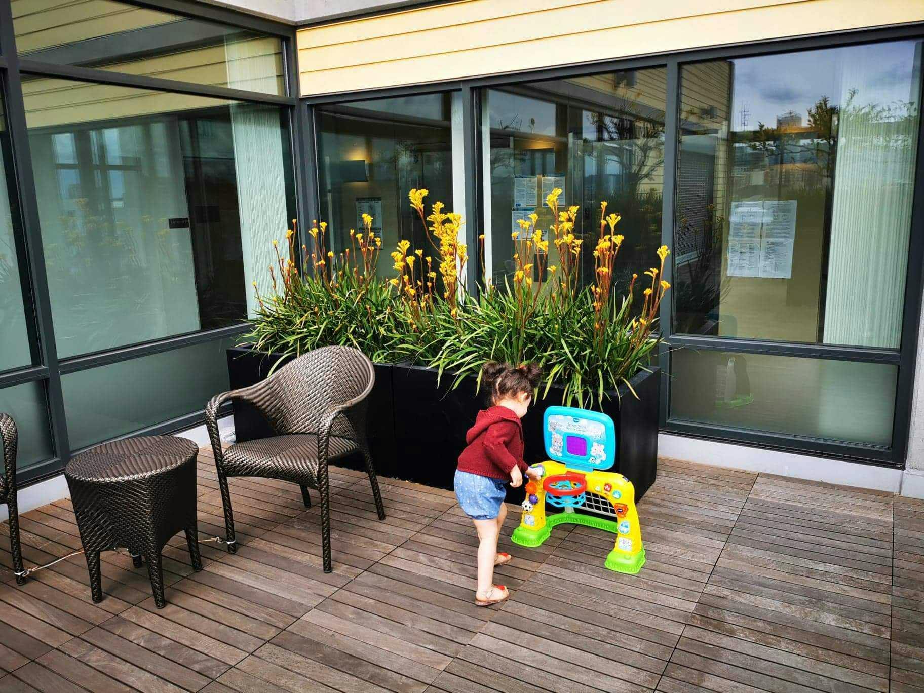 Child playing with a toy on a patio