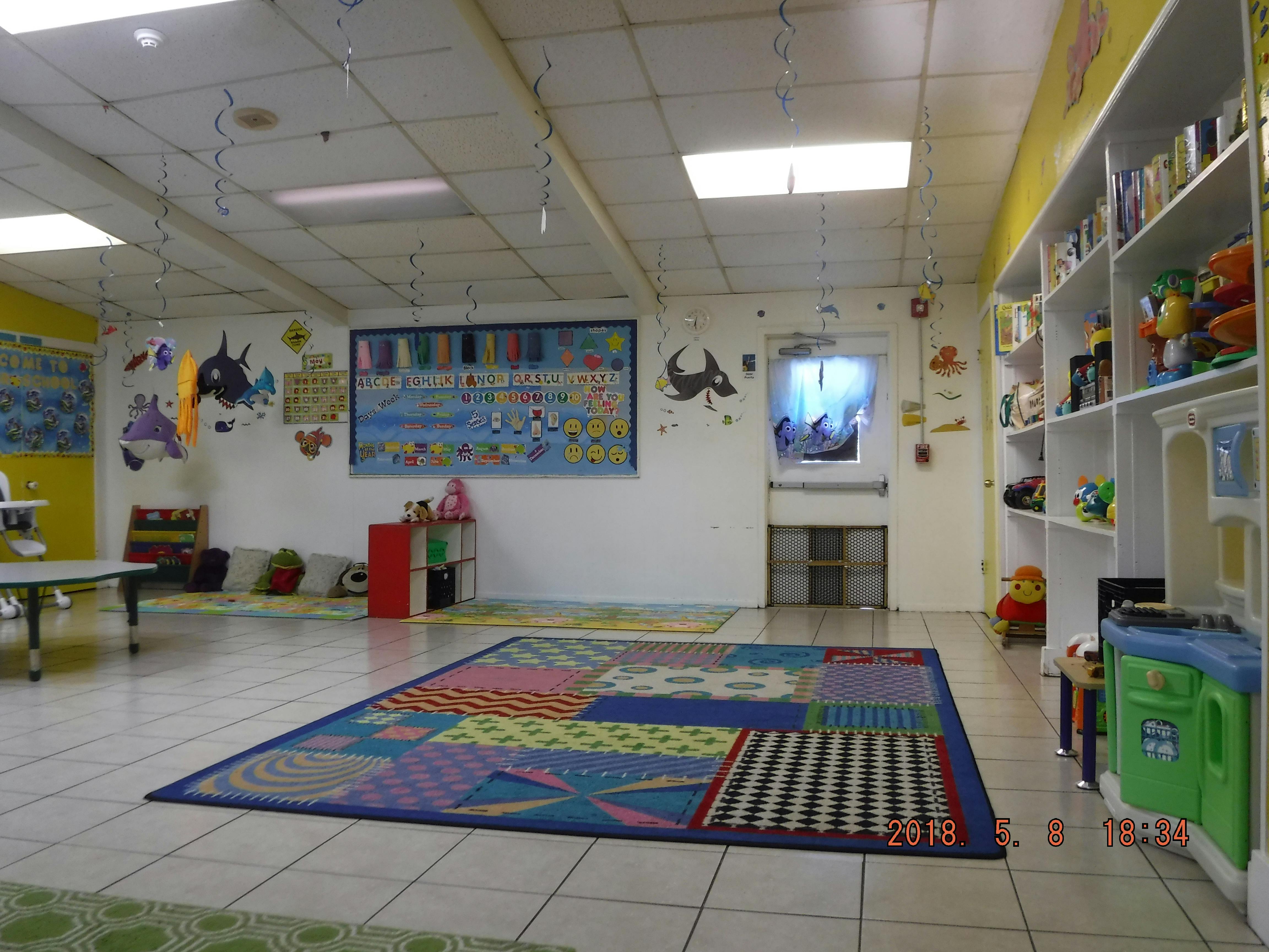 Empty classroom with colorful rugs and shelves
