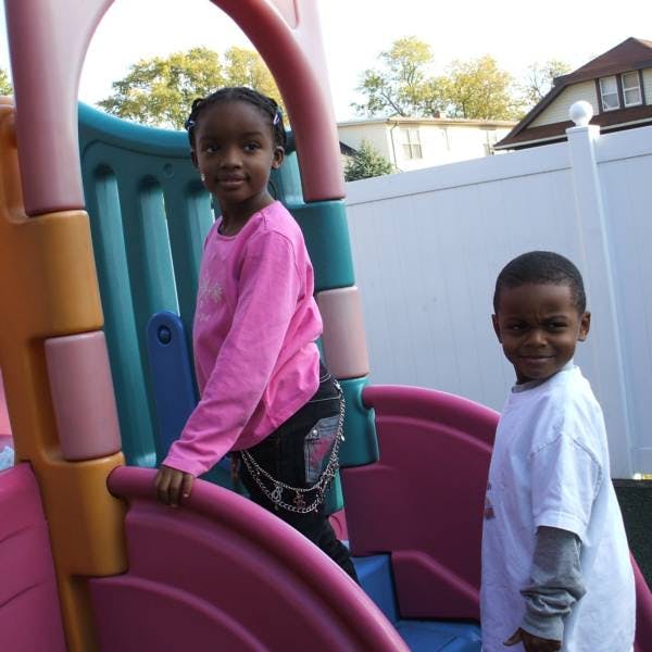 Two children on a colorful playground slide