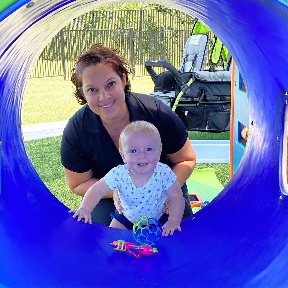 Person and child in a blue play tunnel