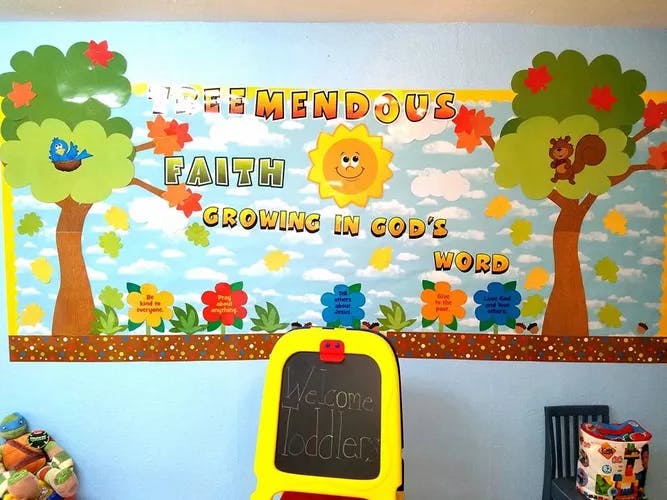 Bulletin board with trees, sun, and text "Tremendous Faith Growing in God's Word"