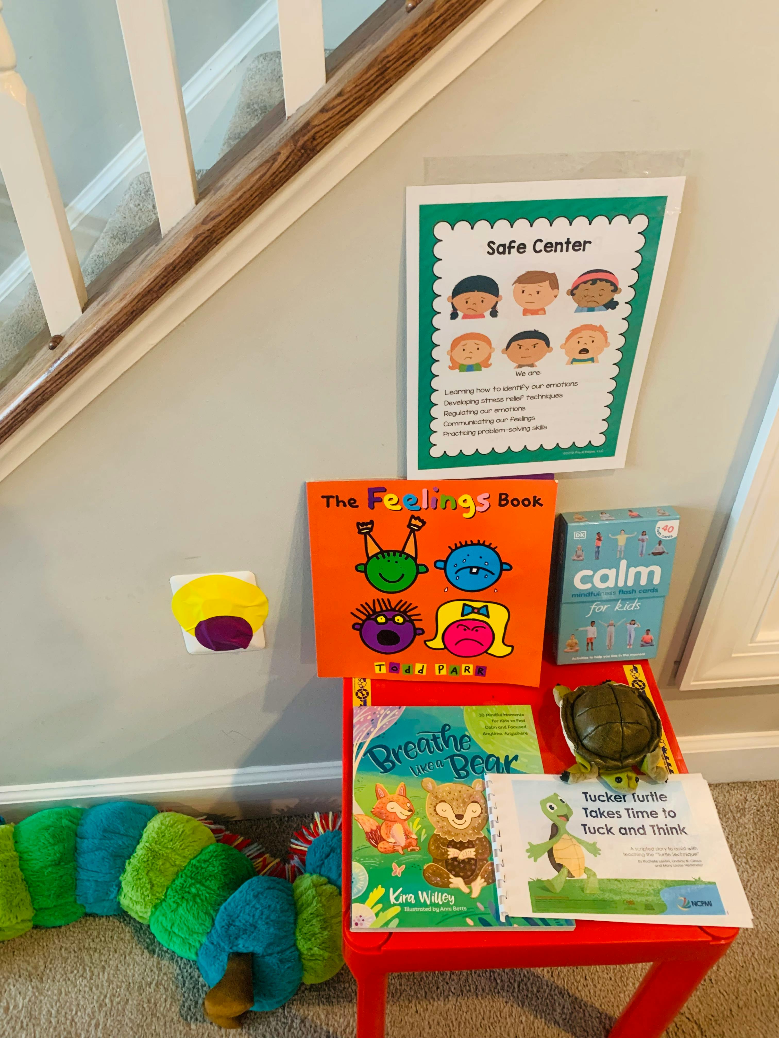 Safe Center sign, books, and turtle toy on a red table