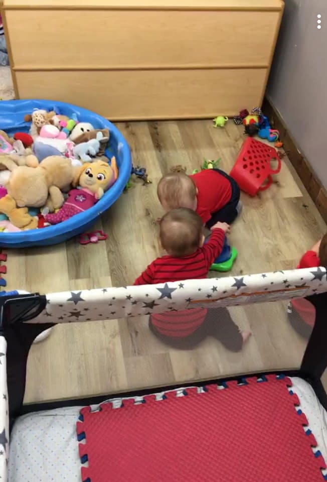 Two children playing with toys on a wooden floor